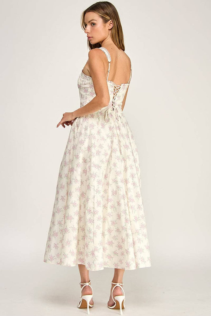 Woman wearing a white floral dress on a plain background
