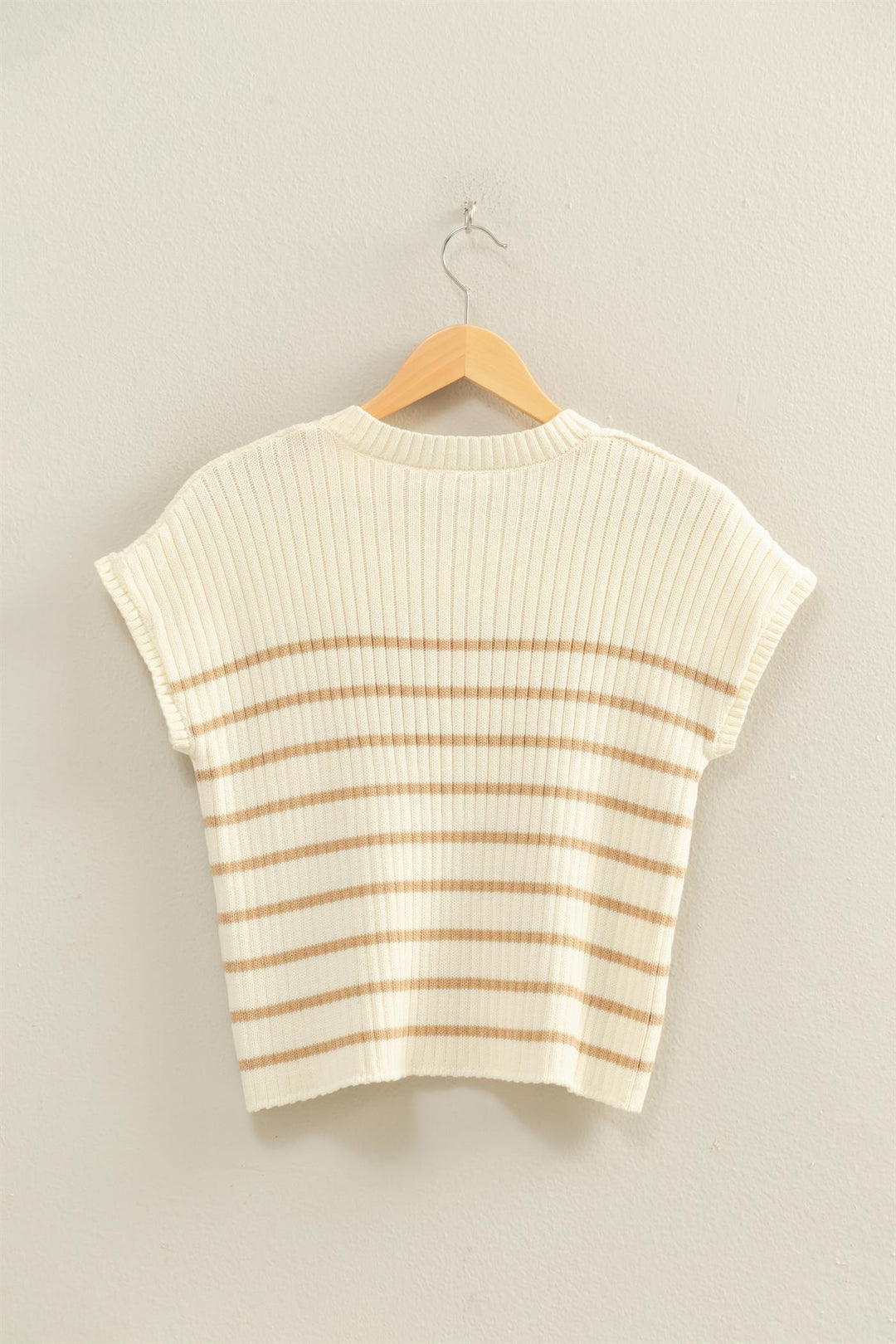 Striped sweater on a hanger against a plain background