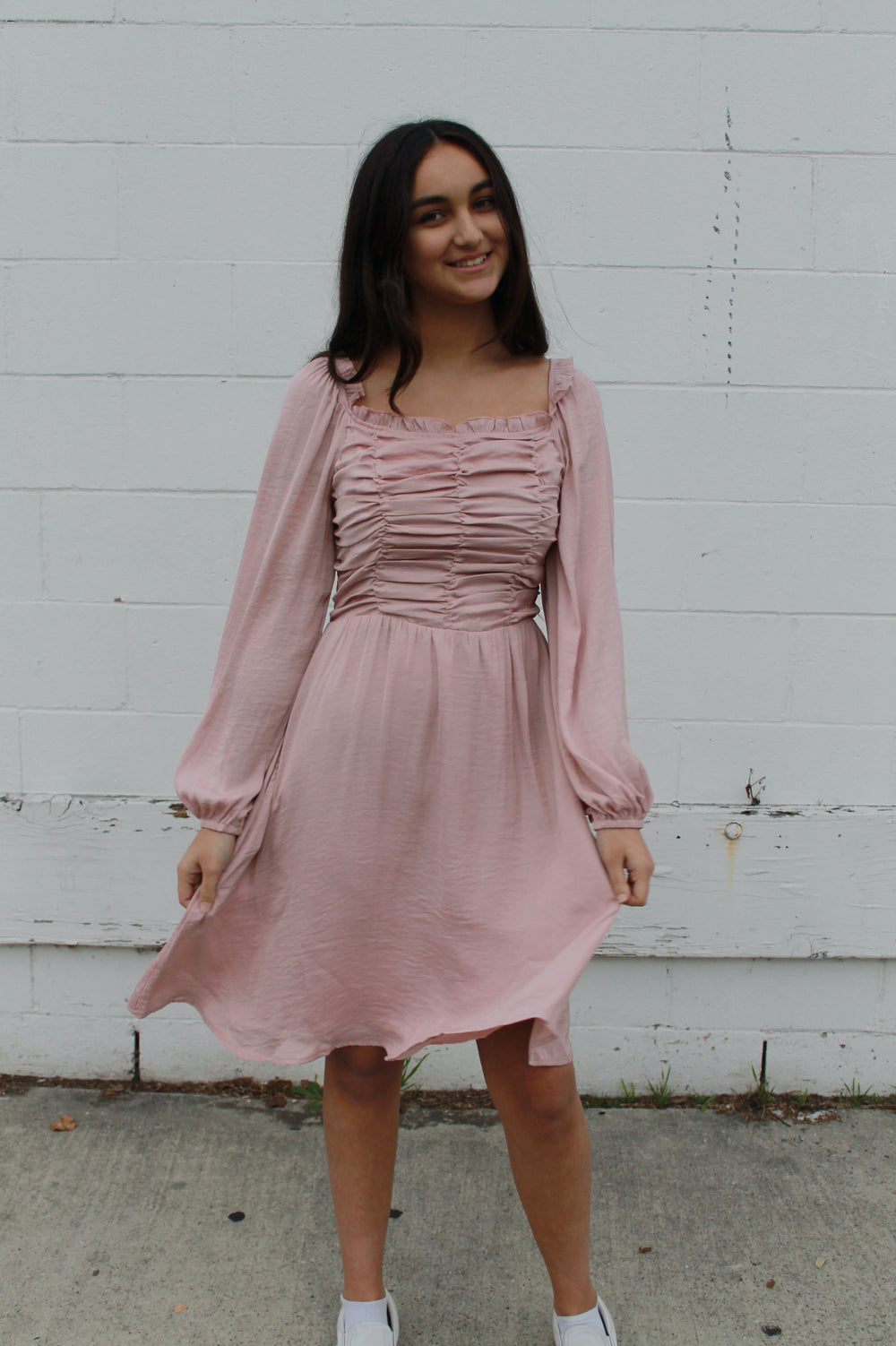Blush pink ruffled top dress with long sleeves and pockets, knee length.