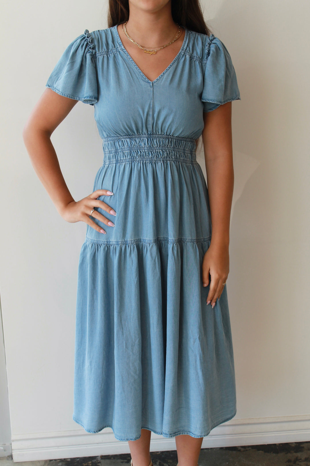 Woman wearing a blue dress against a plain background