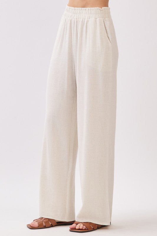 Beige linen wide leg pants with elastic waistband shown at angle